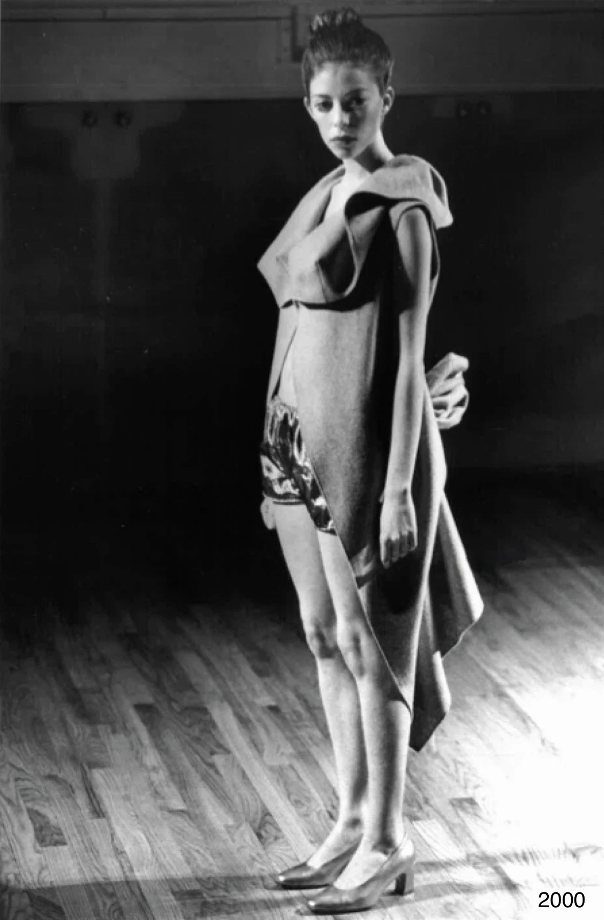 Black and white photograph of a person in a garment with a large folded collar.
