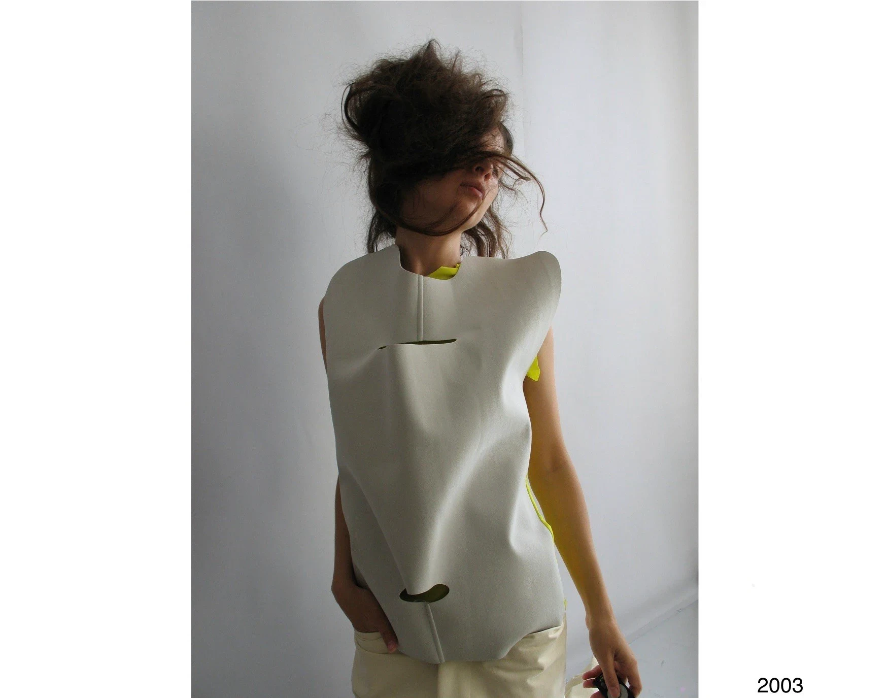 A person wearing a stiff gray sculptural top.
