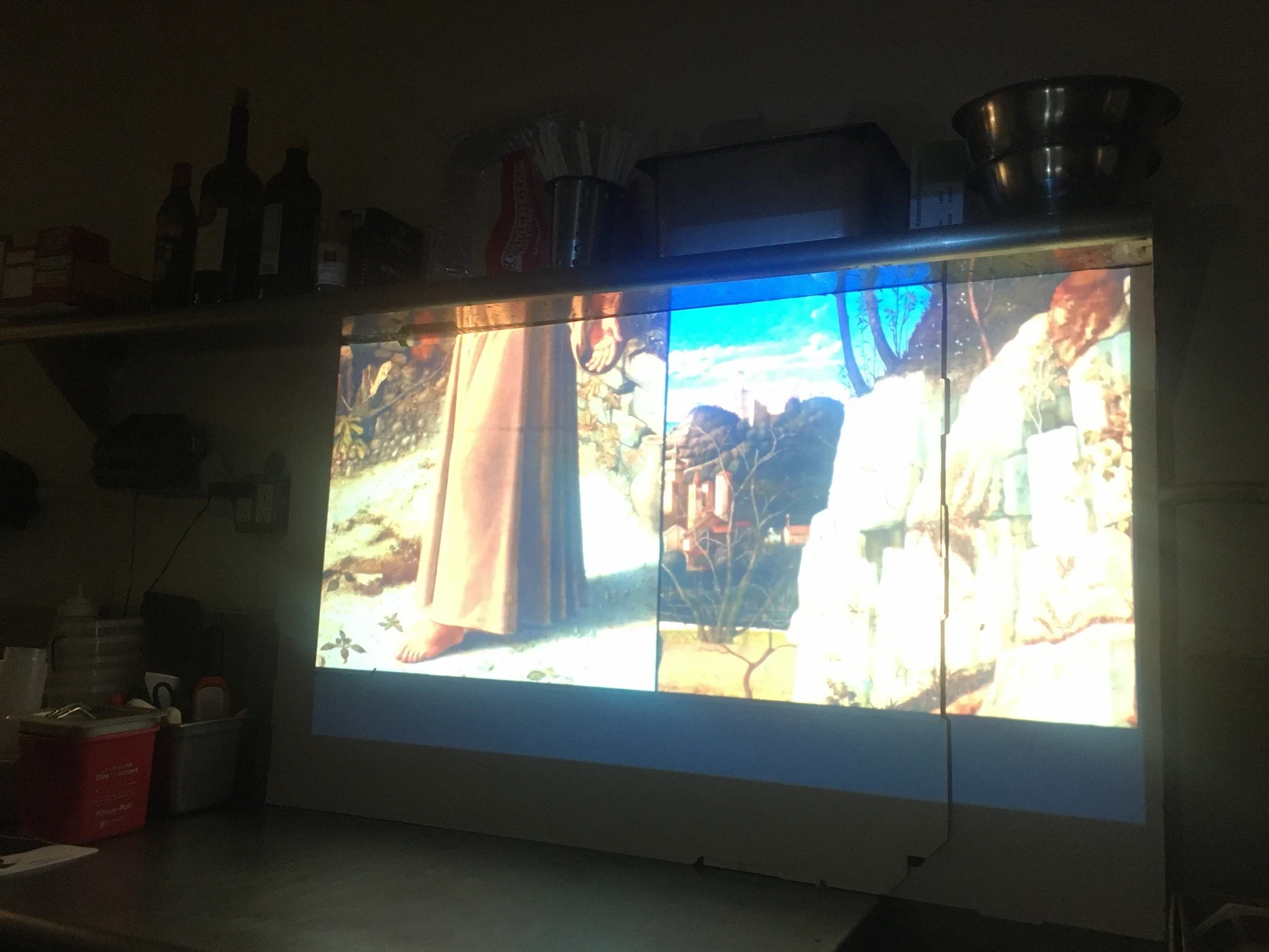 A colorful video projection inside the darkened pizza shop.