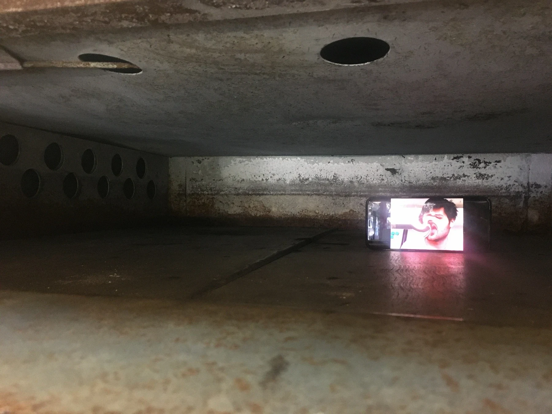 A video playing in a dark basement space.