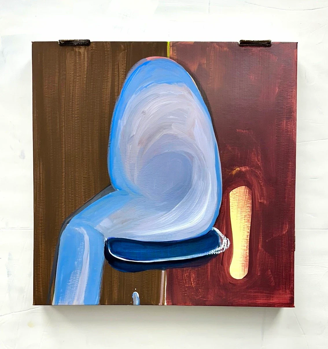 A blue curved form against a dark red rectangular background.