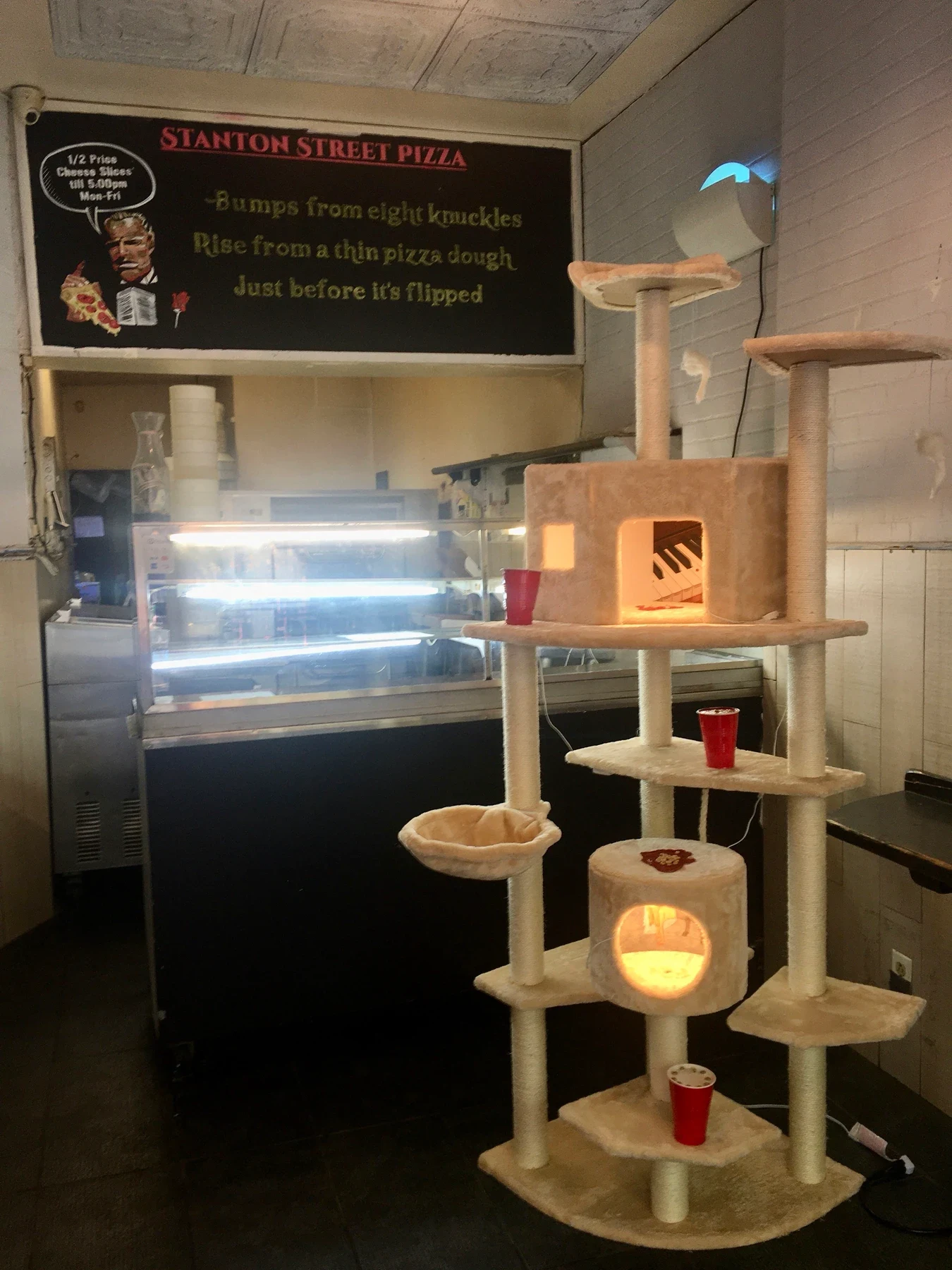 An installation beside a display case inside the pizza shop.