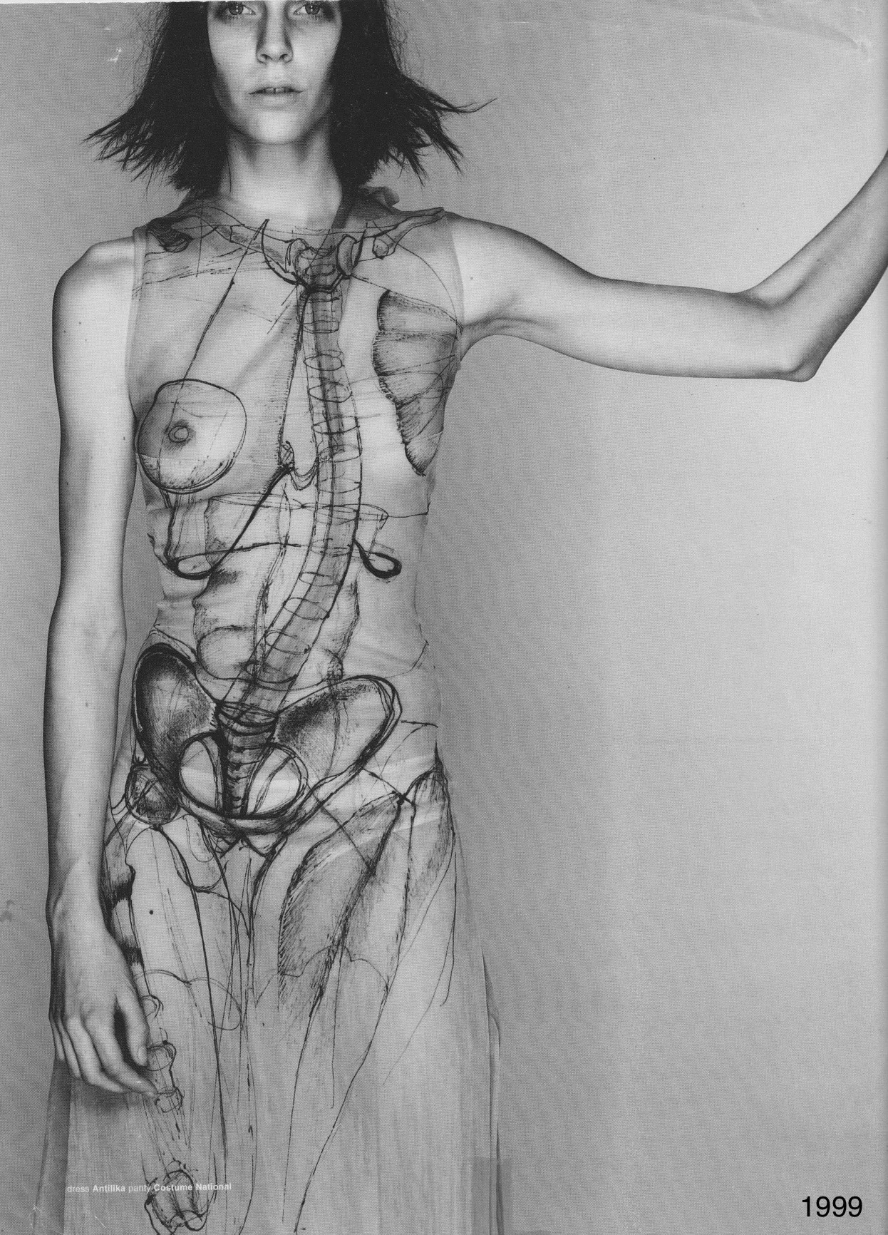 Black and white photograph of a person in a printed sleeveless dress.