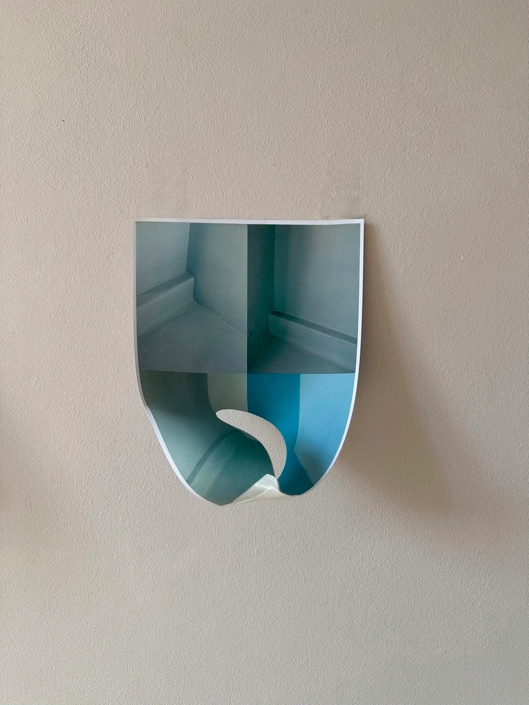 A small blue photograph curled outward from the wall.