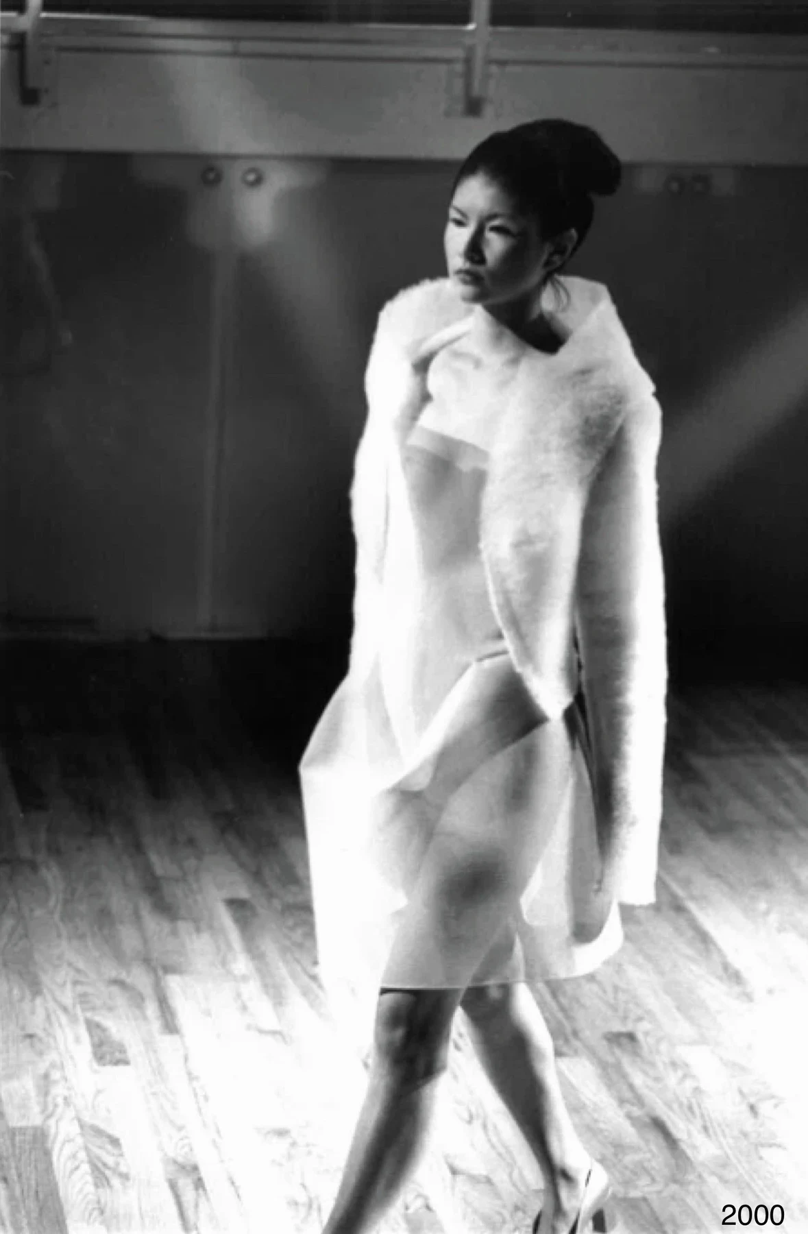 Black and white photograph of a person in a pale layered dress.