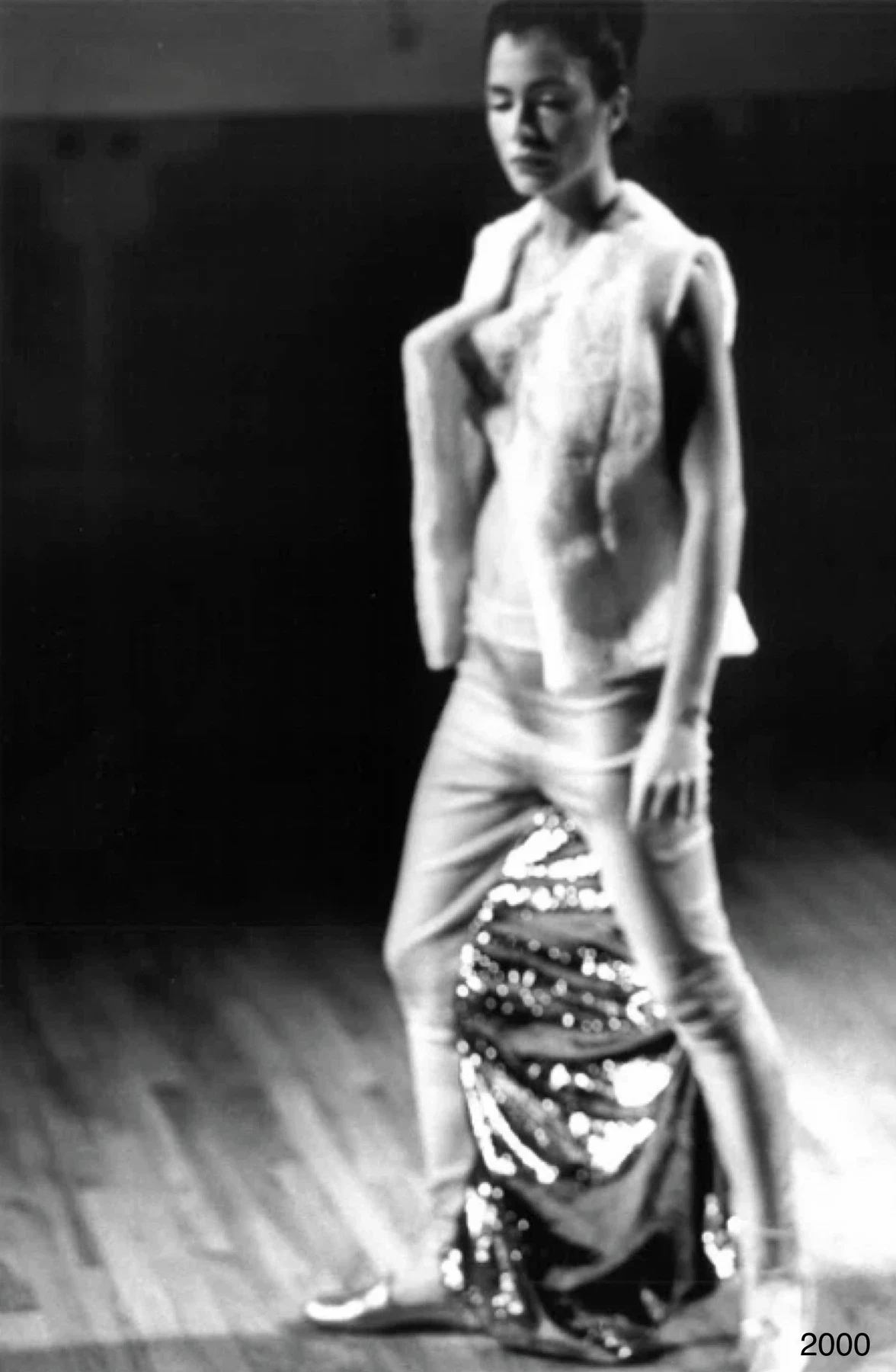 Black and white photograph of a person wearing a garment with gathered metallic fabric.